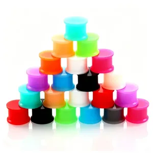 Vista detallada de cerca de túneles y expansores de silicona de colores para perforaciones.