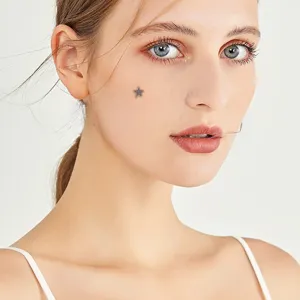 Detailed close-up view of a titanium pentagram micro dermal piercing stud worn on cheek.