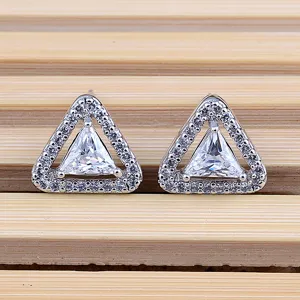Primo piano dettagliato di orecchini a lobo geometrici a triangolo con zirconi scintillanti.