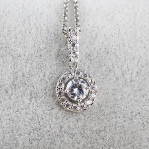 Mooie zilverkleurige metalen ronde zirkonia hanger ketting close-up detailopname.