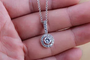 Gedetailleerd aanzicht van een zilveren zirkonia ronde hanger ketting met fonkelende stenen.