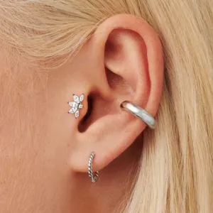 Gros plan sur les bijoux de piercing en titane pour cartilage et tragus avec zircons.