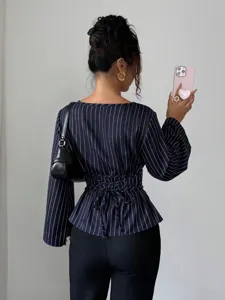 Detail view of the striped long sleeve blouse showing the lace-up waist and back design.