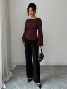 Detailed view of women's pinstripe long sleeve blouse in rich burgundy paired with trousers.