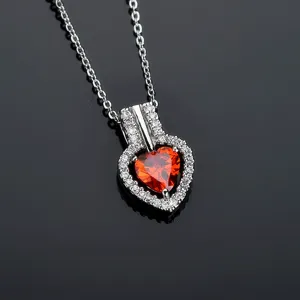 Stunning heart necklace detail showcasing sparkling red zirconia stone and fine chain.
