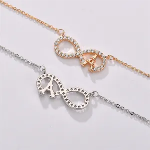 Detailed view of cubic zirconia infinity Eiffel tower pendant necklaces in gold and silver colors.