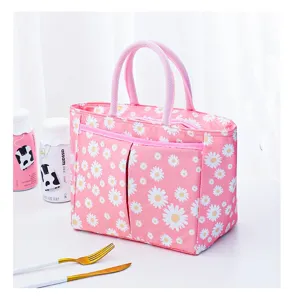 Detailed view of the pink daisy insulated lunch bag with front pocket and sturdy dual handles.