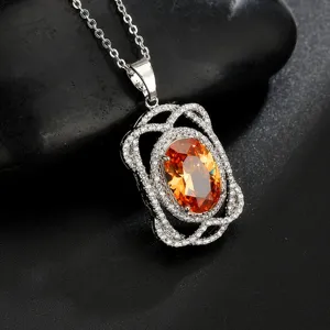 Prachtige ketting met ovale oranje edelsteen hanger en sierlijk wit zirkonia montuur.