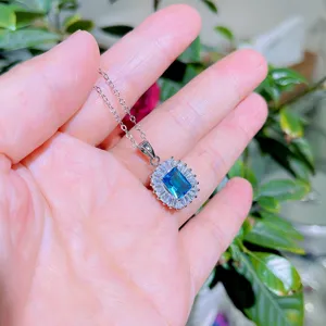 Silberfarbene Halskette mit einem rechteckigen blauen Kristallanhänger und funkelndem Zirkonia-Halo.