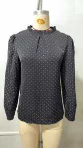 Schwarze langarm Bluse mit Punkten, elegante Rüschen am Rundhalsausschnitt Detail.