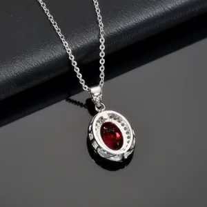Rhodium plated silver necklace detail with oval red crystal pendant and sparkling zircon halo.