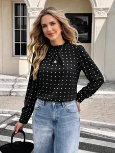 Detaillierte Nahaufnahme mit dem eleganten Pünktchenmuster und dem Stehkragen der Damenbluse.