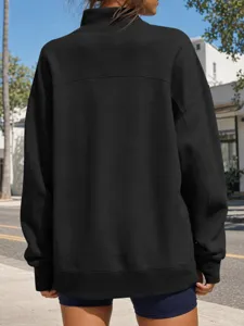 Dettaglio posteriore della felpa nera oversize tinta unita con collo alto e vestibilità comoda.