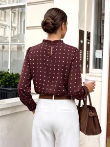 Rückansicht einer schicken burgunderroten Langarm-Chiffonbluse mit Punkten und weißer Hose.