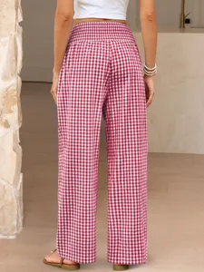 Detailed view of women's red and white gingham high-waist wide-leg pants in indoor setting.