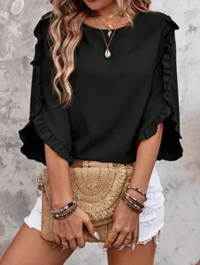 Detailed view of stylish black ruffle sleeve blouse paired with chic woven straw bag.