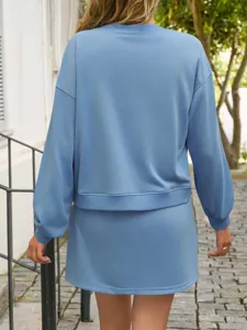 Detail view of the solid color long-sleeve sweatshirt and skirt set, outdoor casual style.