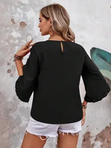 Black ruffle 3/4 sleeve top detail view, featuring round neck and casual style.