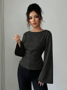 Detailed view of fashionable black and white pinstriped long sleeve blouse with elegant round neck.
