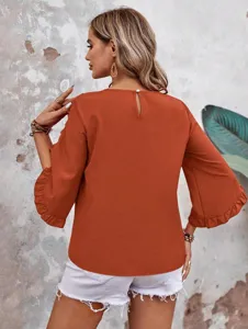 Detail view of women's round neck ruffled three-quarter sleeve blouse back design style