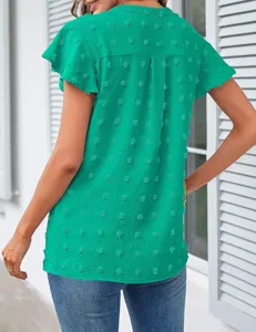 Close-up view of the green V-neck ruffle sleeve blouse showing back pleats and dot texture.