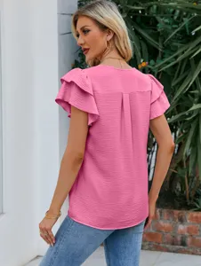 Vue arrière détaillée d'un élégant chemisier rose en mousseline pour femme à volants.