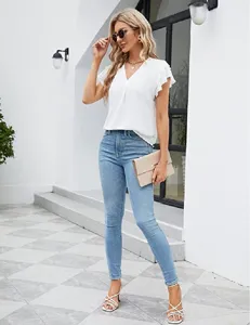 Blouse blanche femme col V à volants manches courtes en mousseline assortie au jean slim.