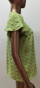 Close-up view of light green women's short sleeve top featuring cute tufted dot and ruffle sleeve.