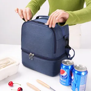 Detail view of blue double-layer insulated lunch bag showcasing food and drinks setup.