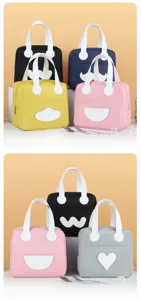Close-up detail shot of cute minimalist lunch bags with various funny white face designs and handles.