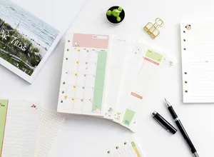 Detailed view of A6 6-ring loose leaf planner refills with colorful monthly and daily layouts.