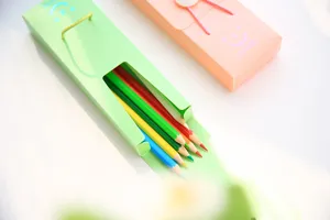 Close-up detail shot of colorful pencil set with cute smiley face drawer box packaging.