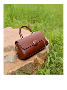 Close-up detail of the brown leather top handle handbag showcasing fine texture and hardware.