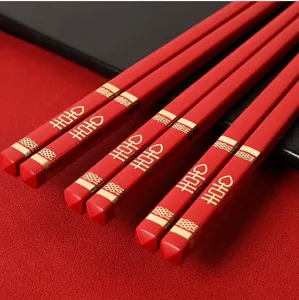 Rotes chinesisches Hochzeitsstäbchen-Set mit goldenem Doppelglück-Muster Detailaufnahme.
