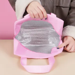 Portable pink thermal lunch bag with insulated aluminum foil lining for school and office use.