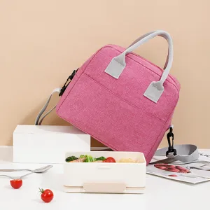 Detailed shot of pink cationic lunch bag, showing fabric texture, sturdy handles and lunch props.
