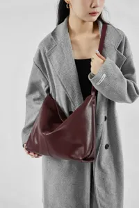 Gedetailleerd overzicht van de bordeauxlederen hobo schoudertas gedragen door model.