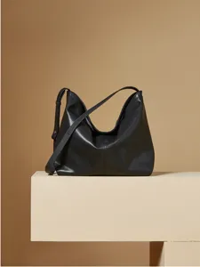 Gedetailleerd overzicht van minimalistische zwarte lederen hobo tas, stijlvol.