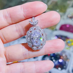 Detailaufnahme eines eleganten ovalen Zirkonia Cluster Anhängers mit Blatthalterung.