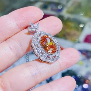 Nahaufnahme Detail des eleganten ovalen orangefarbenen Zirkon Anhängers mit funkelnden Steinen.