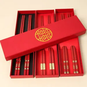 Rote Hochzeits-Essstäbchen-Geschenkbox mit goldenen traditionellen Symbolen für Gäste.