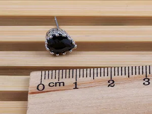 Schwarze Tropfen Zirkonia Ohrstecker mit filigranem hohlen Metalldesign. Detailansicht.