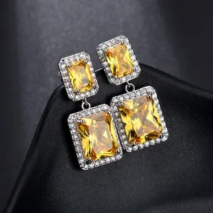 Detailaufnahme zweilagiger quadratischer gelber Zirkonia Ohrringe mit funkelndem Pavé-Besatz.
