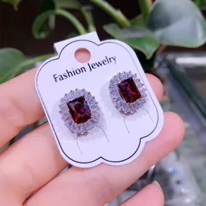 Primo piano di eleganti orecchini a lobo in zircone rosso con strass di cristallo.