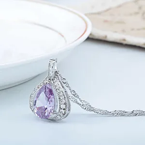 Nahaufnahme des eleganten violetten tropfenförmigen Zirkonanhängers mit glitzernden Steinen.