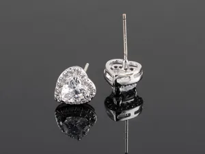 Nahaufnahme Detail von Herz Zirkonia Ohrringen mit Silber Nadel, glitzernde Zirkonsteine.