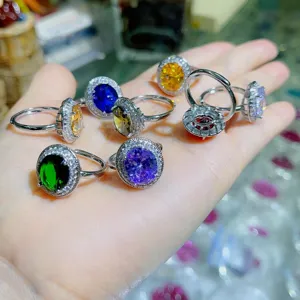 Nahaufnahme von luxuriösen bunten Edelstein-Ringen mit funkelndem Zirkonia-Halo-Design.