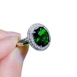 Wunderschöner ovaler grüner Zirkonring mit funkelndem doppelten Halo aus weißen Steinen am Band.
