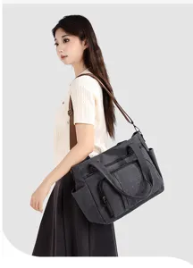 Detail view of the vintage canvas shoulder travel bag, showing side pockets and double handles.
