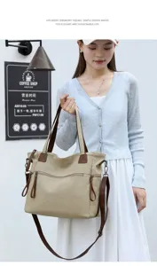 Canvas shoulder bag detail showing dual straps, front zipper pocket, and elegant travel design.